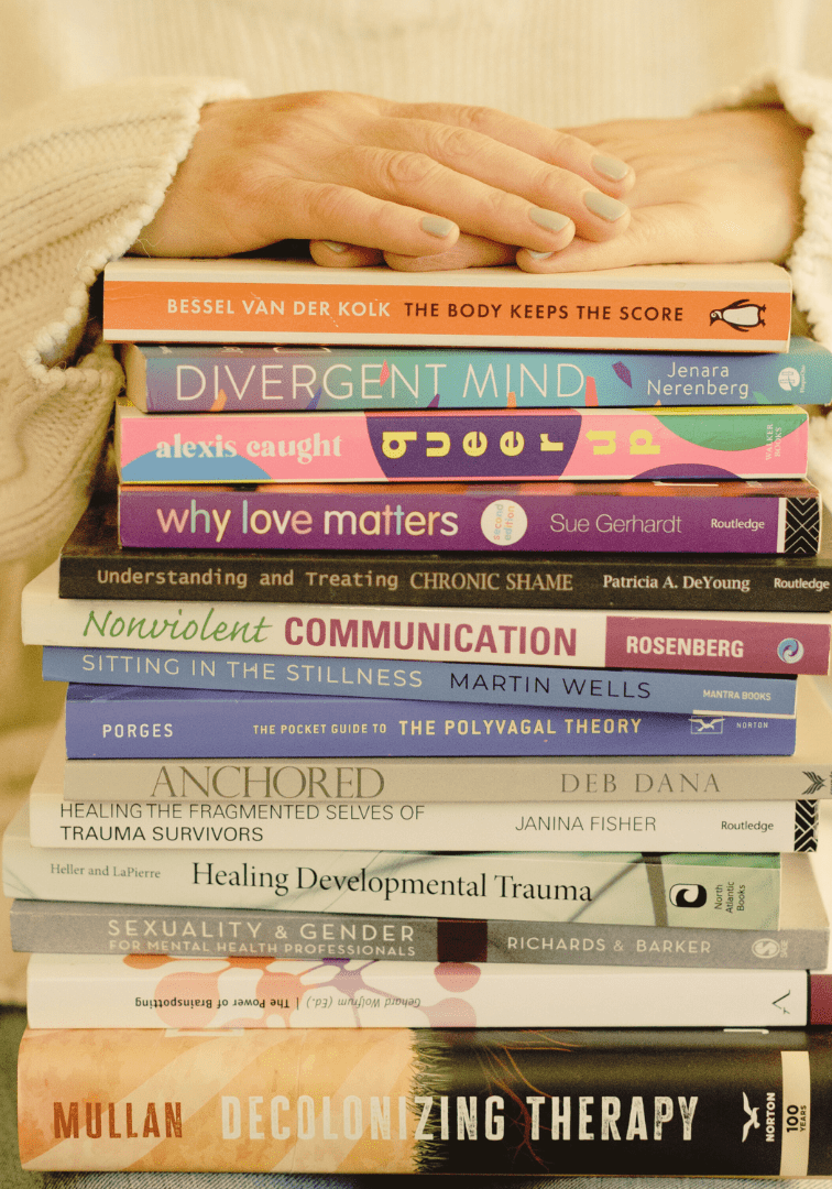 A person sitting in front of a stack of books.